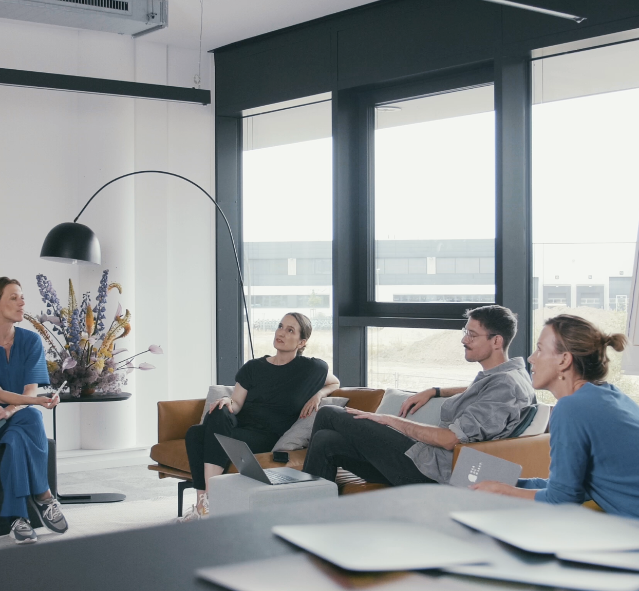 Alle Wer DU Warst Masterclass Expert*innen sitzen zusammen im Ship in Köln und unterhalten sich Mel Breese Carina Fritz Benni Bauerdick und Gunda Tibelius sind im Bild im Hintergrund ein Flip Chart auf dem Steht Herzlich willkommen zum Workshop Abschied nehmen von Kindern und Sternenkindern