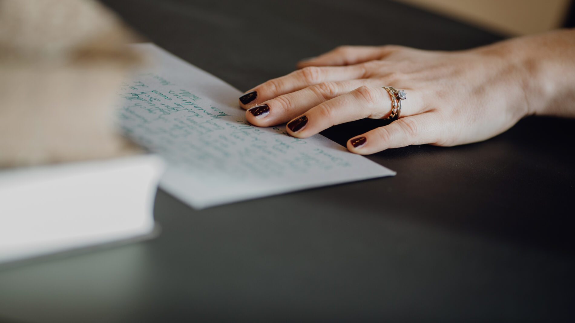 Man sieht die Hand einer Trauerrednerin auf einer Moderationskarte liegen auf einem Tisch zur Vorbereitung der Trauerrede für Wer Du Warst